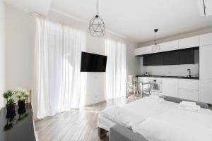 um quarto branco com uma cama grande e uma cozinha em Appartamento: BuenosAires79 em Milão