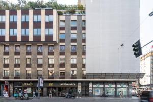 um grande edifício numa rua da cidade com um semáforo em Appartamento: BuenosAires79 em Milão