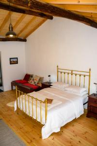 een slaapkamer met een groot bed en een bank bij Casa das Pedras Country Retreat in Santo António das Areias