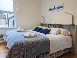ein Schlafzimmer mit einem großen Bett mit zwei Kissen darauf in der Unterkunft Charming 3BR in Trendy Tottenham Neighborhood in London