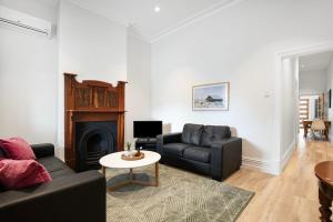 a living room with two couches and a fireplace at Beachside Cottage Glenelg Sth in Glenelg