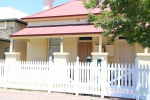 a white picket fence in front of a house at Beachside Cottage Glenelg Sth in Glenelg