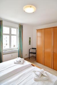 ein Schlafzimmer mit einem großen weißen Bett und einem großen Fenster in der Unterkunft Miramar App. 21 in Ahlbeck