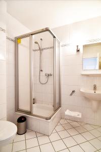 a bathroom with a shower and a toilet and a sink at Miramar-App-21 in Ahlbeck