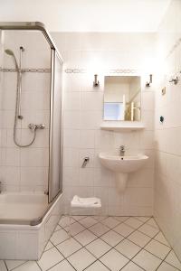 a white bathroom with a shower and a sink at Miramar-App-21 in Ahlbeck