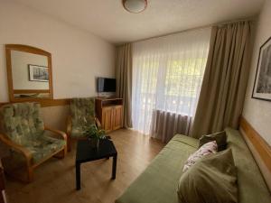 a living room with a couch and chairs and a window at Hotel U STUDÁNKY in Jablunkov
