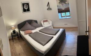 een slaapkamer met een bed en een stoel erin bij Ferienwohnung Klitzschen Nähe Torgau in Mockrehna