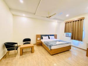 a bedroom with a bed and a desk and a chair at Mauryan's Premier in Gaya