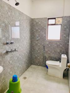 a bathroom with a toilet and a sink and a window at Mauryan's Premier in Gaya