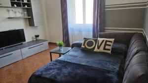 ein Wohnzimmer mit einem Sofa und einem TV in der Unterkunft VAL D'ORCIA DELUXE 2, RAFFINATA CASA immersa nel verde con WiFi, giardino e parcheggio in Montalcino