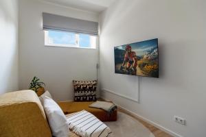 uma sala de estar com uma televisão pendurada na parede em Beachside Lounges California Gartenlounge C1 em Kalifornien