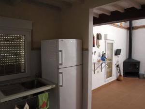 a kitchen with a white refrigerator and a stove at La Casina de Carcaboso in Carcaboso