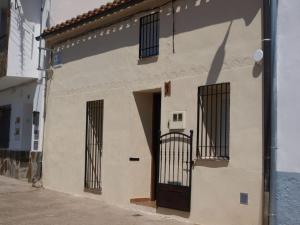 a building with barred windows and a door at La Casina de Carcaboso in Carcaboso
