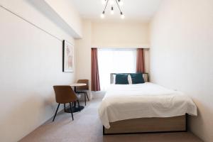 Schlafzimmer mit einem Bett, einem Tisch und einem Fenster in der Unterkunft Fujiterrace Yoga in Tokio