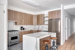 una cocina con armarios de madera y electrodomésticos de acero inoxidable en Soho 3br w wd elevator nr cafes restaurants NYC-1043 en Nueva York