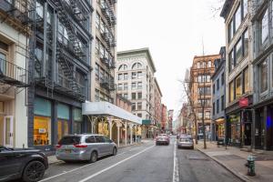 una calle de la ciudad con coches aparcados en la calle en Soho 3br w wd elevator nr cafes restaurants NYC-1043 en Nueva York