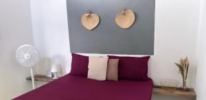 a bedroom with a purple bed with two hearts on the wall at Yay Lodge SIARGAO, private room 2 with AC & hot shower and fast Starlink Wifi in General Luna