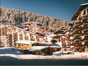 a group of buildings in the snow with a mountain at 40m2 - Ski aux pieds - La Tania - Parking couvert in La Tania