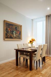 uma sala de jantar com uma mesa com cadeiras e um quadro em Art Palace - LoftAffair Collection em Cracóvia