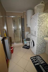a bathroom with a shower and a washing machine at апартамент Жаклин к.к. Хармони Хилс in Rogachevo