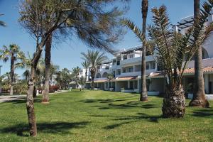 un groupe de palmiers devant un bâtiment dans l'établissement Hotel Riu Tikida Dunas - All inclusive, à Agadir