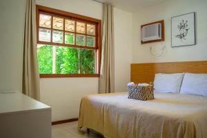 sypialnia z łóżkiem z oknem i telewizorem w obiekcie Meu Paraíso em Búzios w mieście Búzios