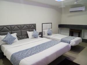 two large beds in a room with a fireplace at HOTEL RK VILLA in Vadodara