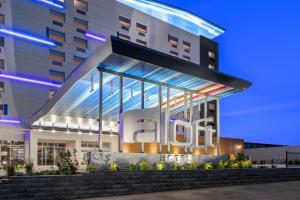 a building with a lit up sign in front of it at Aloft Chicago Schaumburg in Rolling Meadows