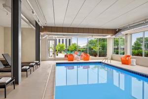 una piscina en una habitación de hotel con toques naranjas en Aloft Chicago Schaumburg, en Rolling Meadows
