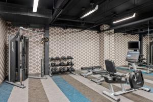 a gym with tread machines and a tv on the wall at Aloft Chicago Schaumburg in Rolling Meadows