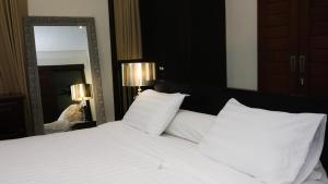 Un dormitorio con una cama blanca y un espejo. en Villa 3-Bedroom with pool, en Canggu