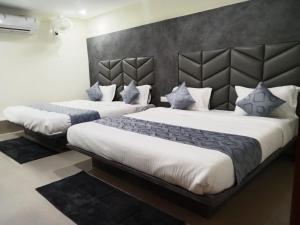 2 Betten in einem Hotelzimmer in Weiß und Blau in der Unterkunft HOTEL RK VILLA in Vadodara