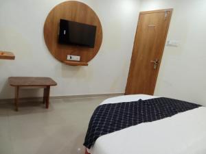 um quarto com uma cama e uma televisão na parede em HOTEL RK VILLA em Vadodara