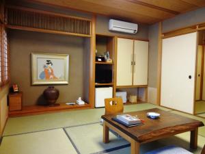 - un salon avec une table en bois dans l'établissement Yamatoya, à Toyooka