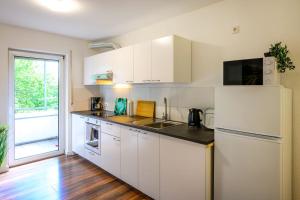 cocina con armarios blancos y nevera blanca en Nice Apartment in Marburg, en Marburg an der Lahn