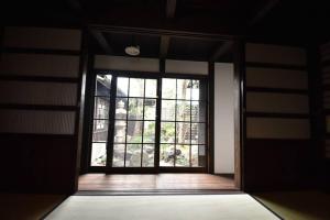 una puerta abierta a una habitación con una ventana grande en 庭の宿 帆や niwayado hoya, en Yaizu