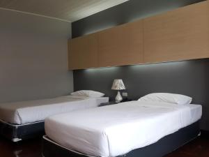 2 Betten in einem Hotelzimmer mit weißer Bettwäsche in der Unterkunft Florida Hotel in Bangkok