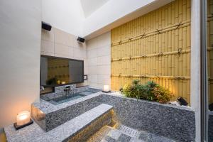 Hotel P'sResort Adults only 大人専用 في طوكيو: حمام كبير مع حوض استحمام وتلفزيون