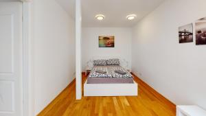 ein Schlafzimmer mit einem Bett in einem Zimmer mit weißen Wänden in der Unterkunft Loftwohnung im tollen Hinterhaus in Leipzig