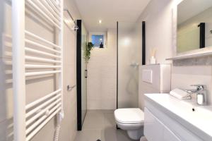 a white bathroom with a toilet and a shower at Optima Apartment Zagreb - Spacious Central Stay in Zagreb