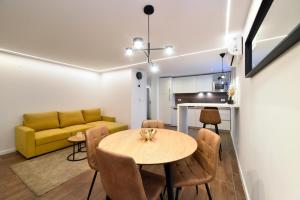 a living room with a table and a yellow couch at Optima Apartment Zagreb - Spacious Central Stay in Zagreb