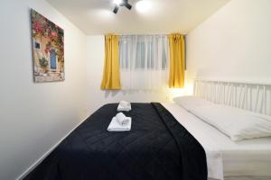 a bedroom with a bed with two white towels on it at Optima Apartment Zagreb - Spacious Central Stay in Zagreb