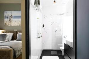 baño con ducha, cama y lavamanos en Hotel Resonanz Vienna en Viena