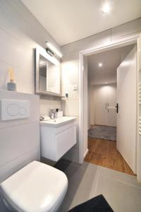 a bathroom with a white toilet and a sink at Optima Apartment Zagreb - Spacious Central Stay in Zagreb