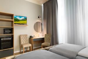 Hotel Resonanz Vienna في فيينا: غرفة في الفندق مع سرير ومكتب