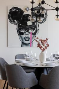a dining room table with a painting of a woman at Premium LUX Apartments Unique Tower Heart of Warsaw by Renters Prestige in Warsaw