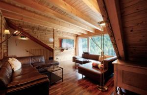 a living room with leather furniture and a large window at Villa Chiara in Sankt Anton am Arlberg