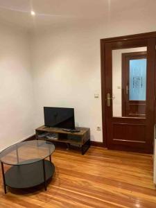 a living room with a glass table and a door at Preciosa casa en Castro Urdiales in Castro-Urdiales