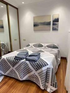 a bedroom with a bed with two towels on it at Preciosa casa en Castro Urdiales in Castro-Urdiales