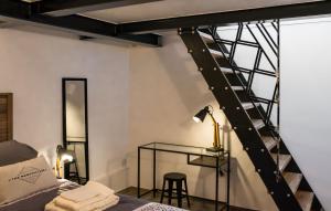 a bedroom with a loft bed with a ladder and a desk at La Cle des Expos "In Paris" in Vanves